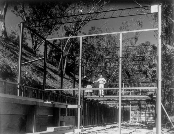 Ray e Charles Eames na estrutura de aço de sua casa em 1949_ Eames Office