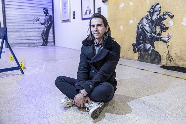 O diretor artístico Eliya Akbas entre os murais com as réplicas da arte de Banksy feita nos Estados Unidos.© Reinaldo Rodrigues/Global Imagens